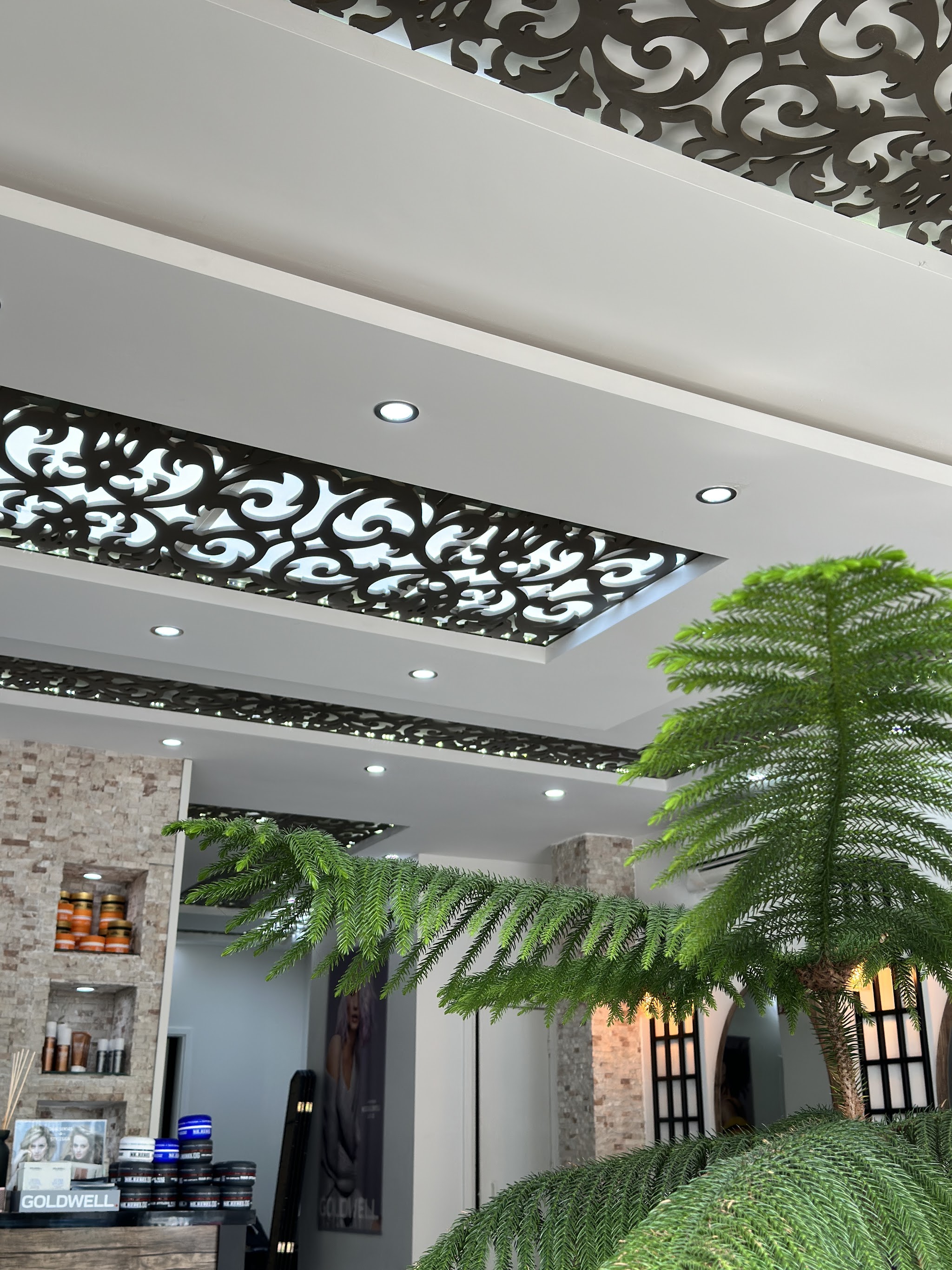 De ronde spiegels en groene planten in Asmin Hairstudio